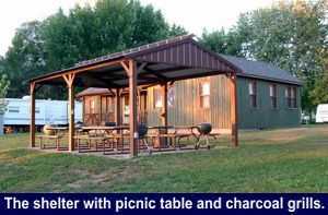 The shelter with picnic table and charcoal grills.